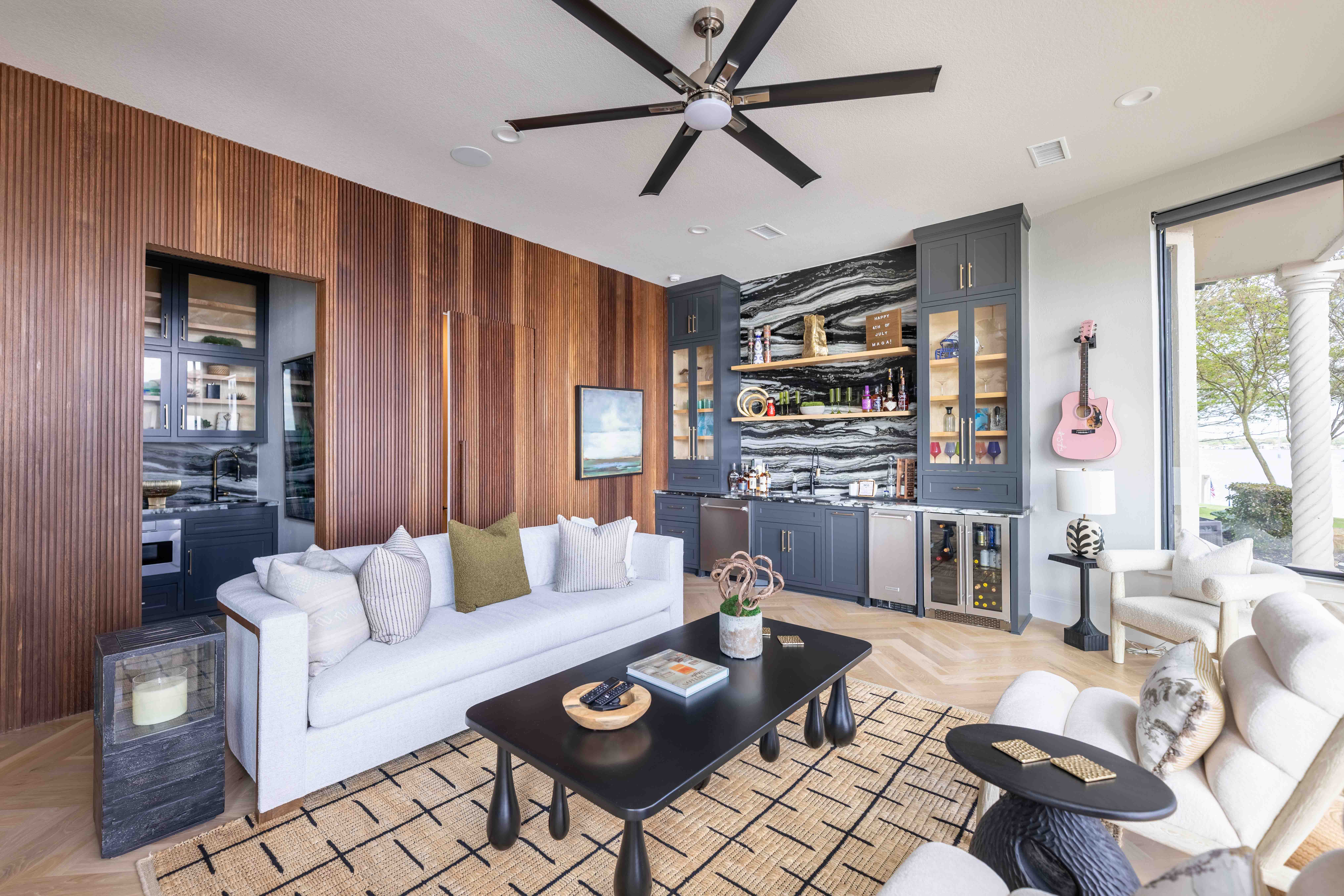 Living room with wood-paneled wall and ceiling fan, Houston real estate listing photo