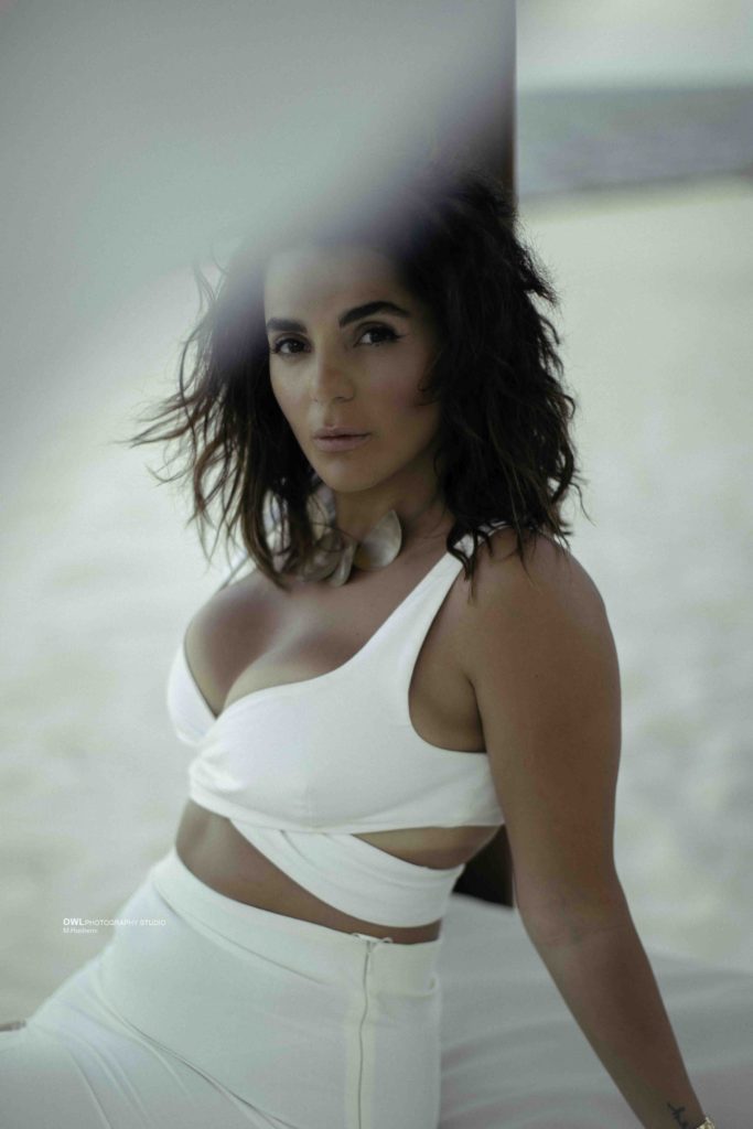 Editorial portrait of woman in white outfit with dramatic lighting