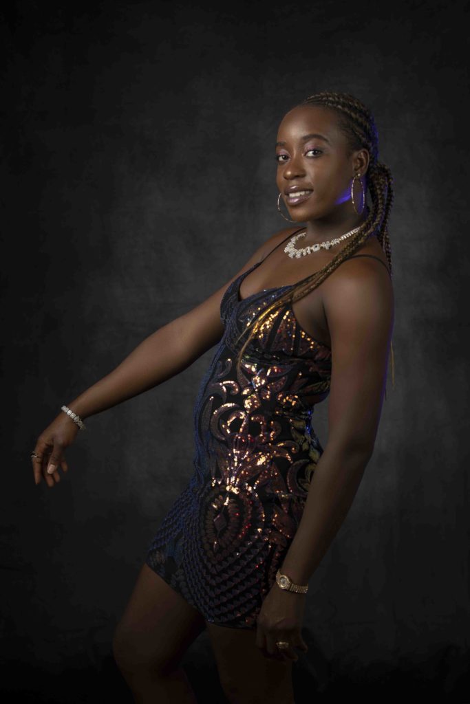 Fashion portrait of woman in sequin dress against dark background