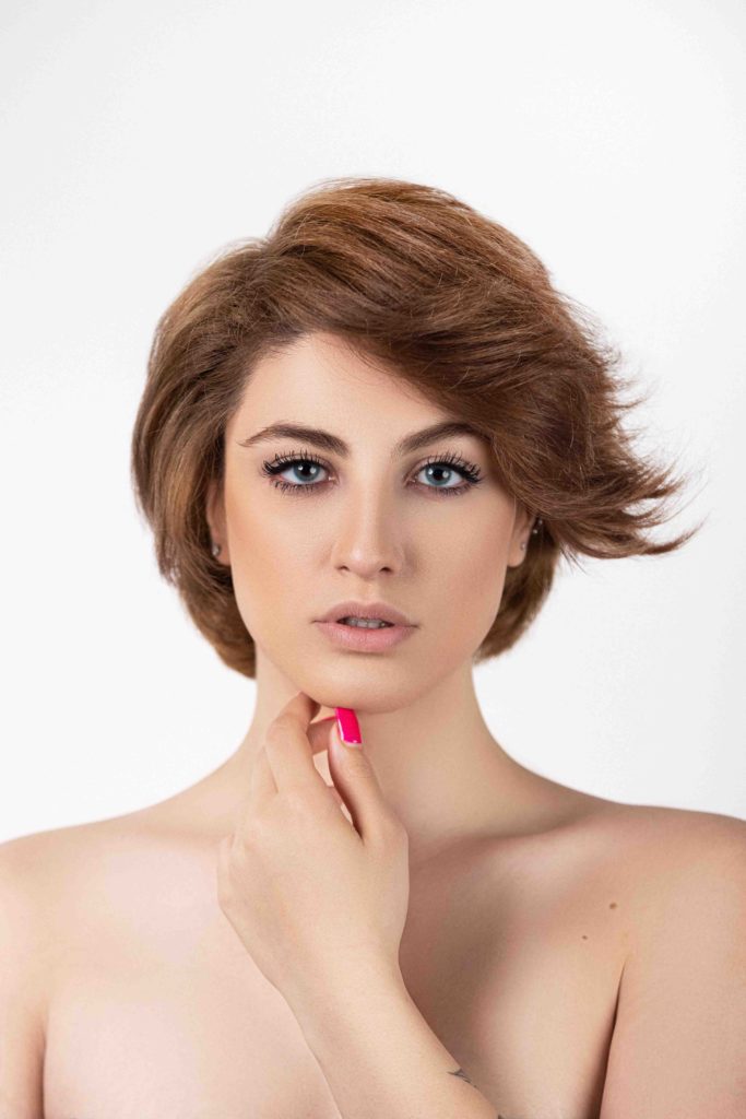 Beauty headshot of woman with short red hair and soft lighting