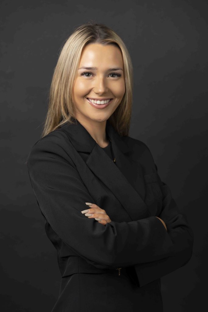 Professional corporate headshot of blonde woman in black blazer