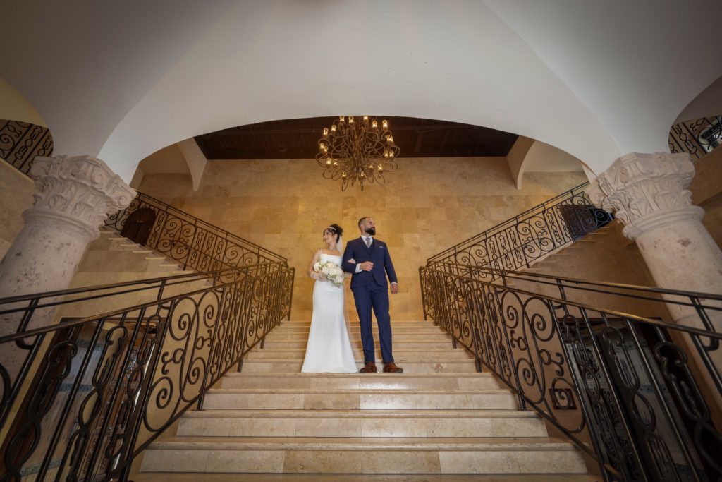 Bride and groom on ornate staircase at wedding venue, Houston wedding photography