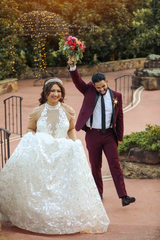 Bride raising bouquet with groom celebrating outdoors, Houston wedding photography