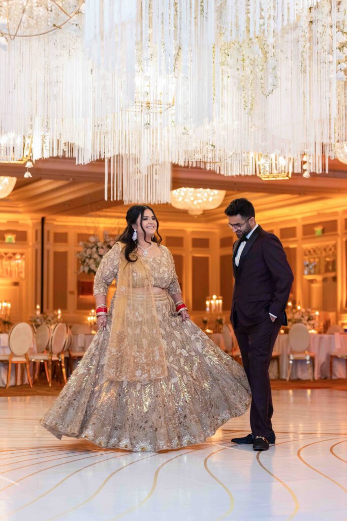 Bride and groom in traditional Indian wedding attire under chandelier, Houston wedding photography